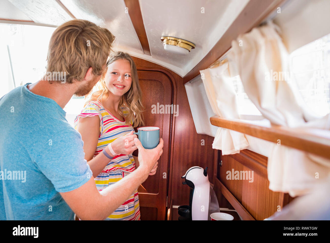 Young couple in sailboat cabin making coffee Stock Photo Alamy