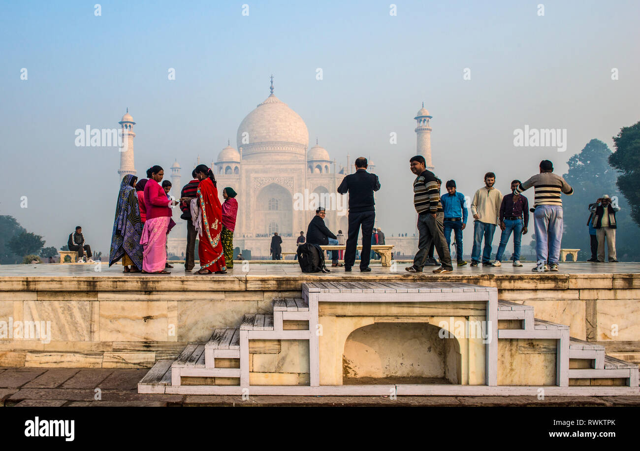 INDIA, AGRA; A group of Indian tourists enjoying the spectacular view of Taj Mahal early in the morning Stock Photo