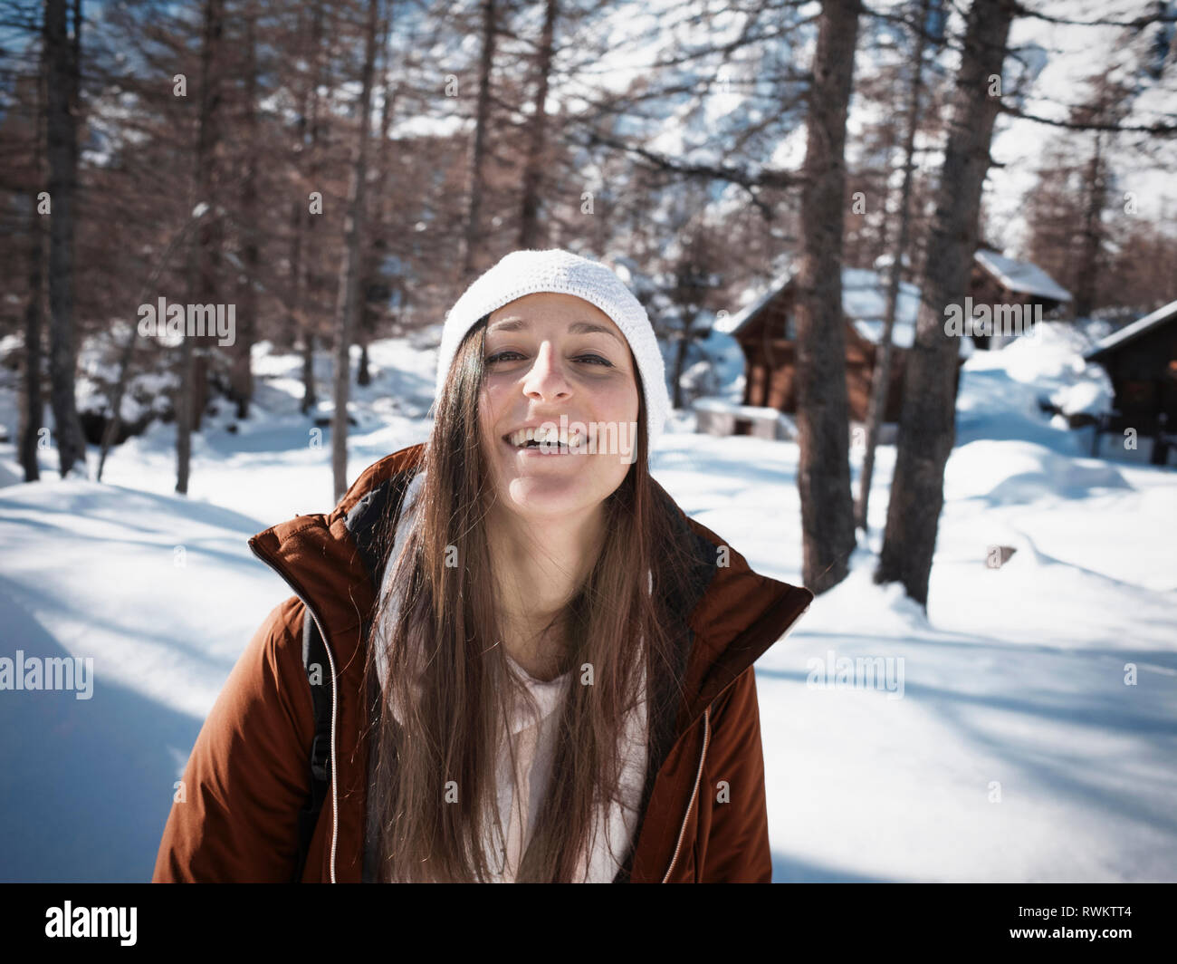 Young woman in knit hat in snow covered forest, portrait, Alpe Ciamporino, Piemonte, Italy Stock Photo