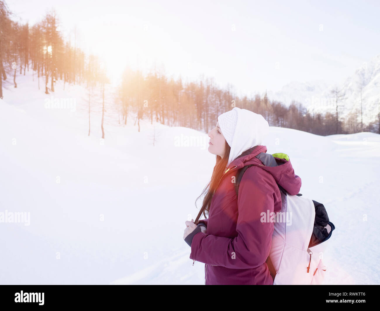 Young woman in knit hat looking out at snow covered landscape, Alpe Ciamporino, Piemonte, Italy Stock Photo