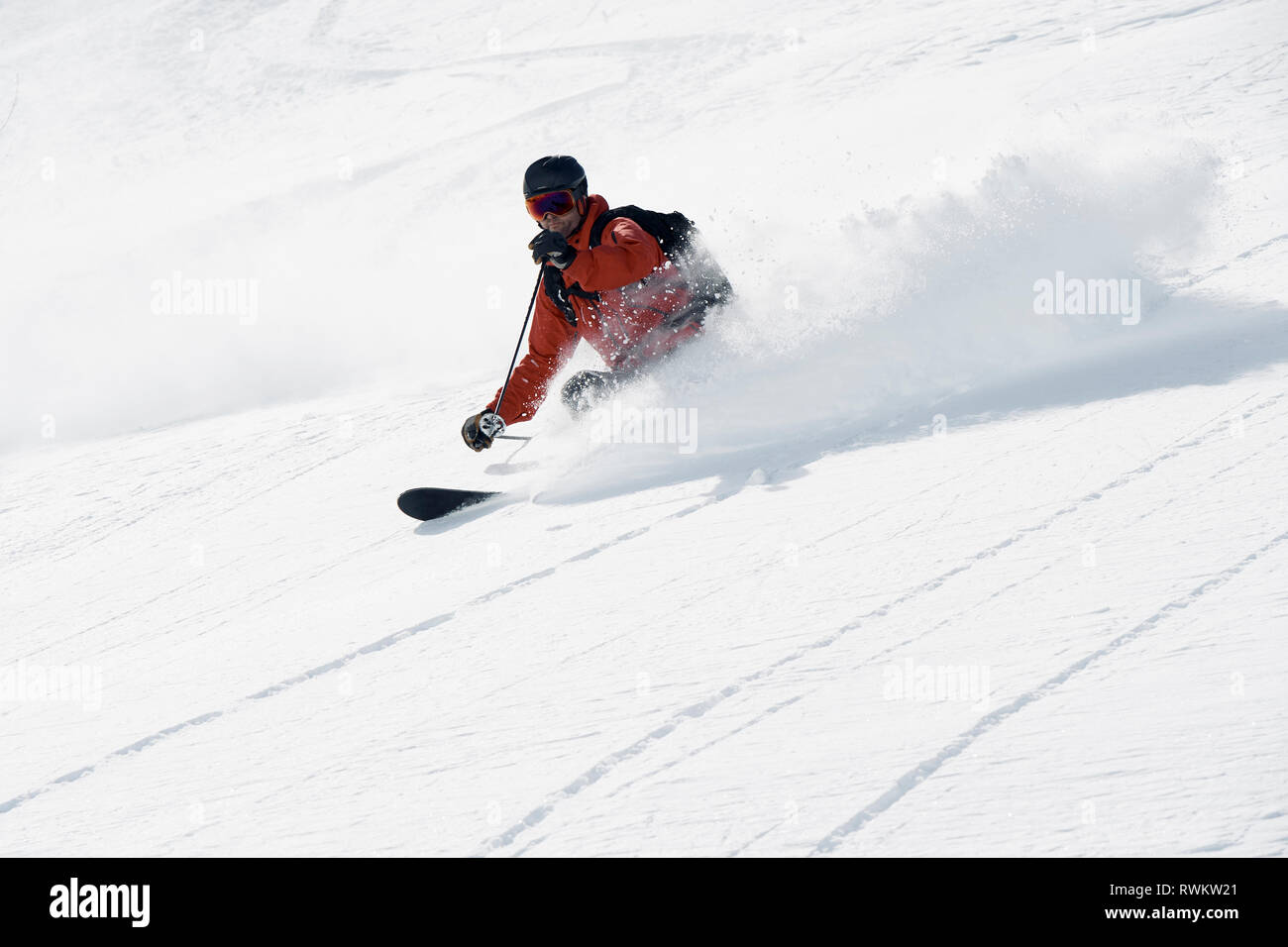 Male skier skiing down mountain, Alpe-d'Huez, Rhone-Alpes, France Stock Photo