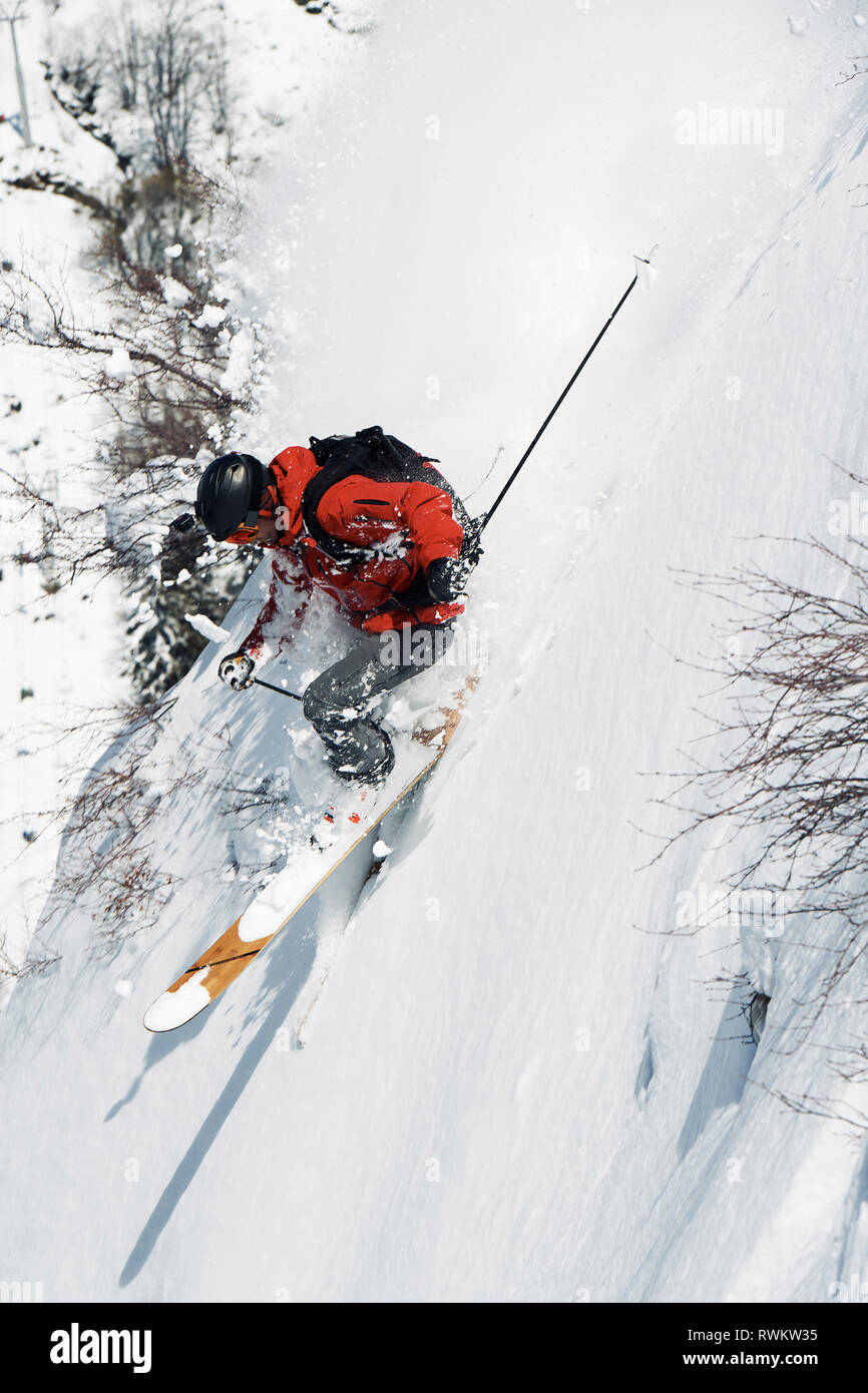 Male skier speeding down vertical mountainside, Alpe-d'Huez, Rhone-Alpes, France Stock Photo