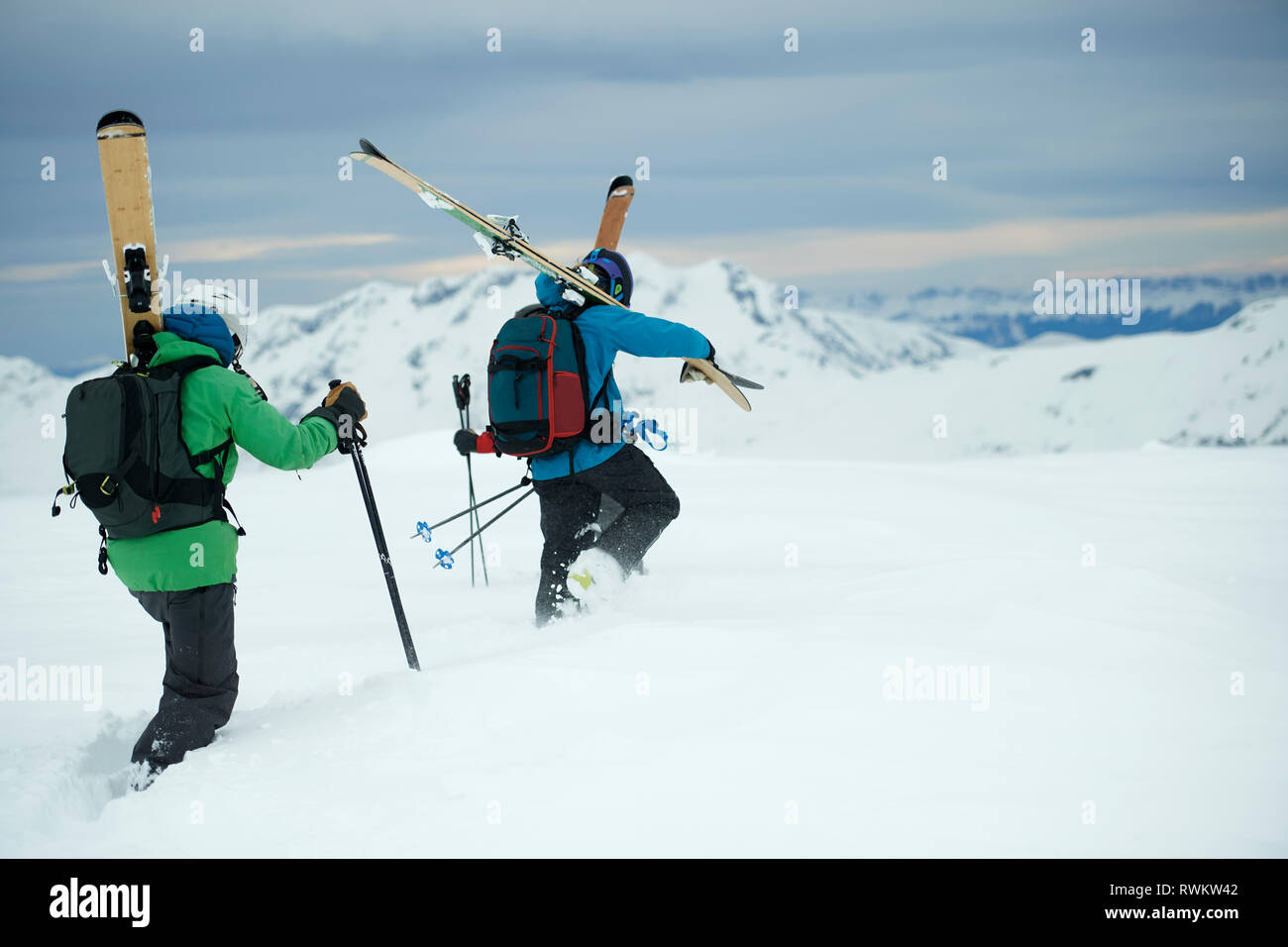 Landscape with two male skiers trudging toward mountain, rear view, Alpe-d'Huez, Rhone-Alpes, France Stock Photo