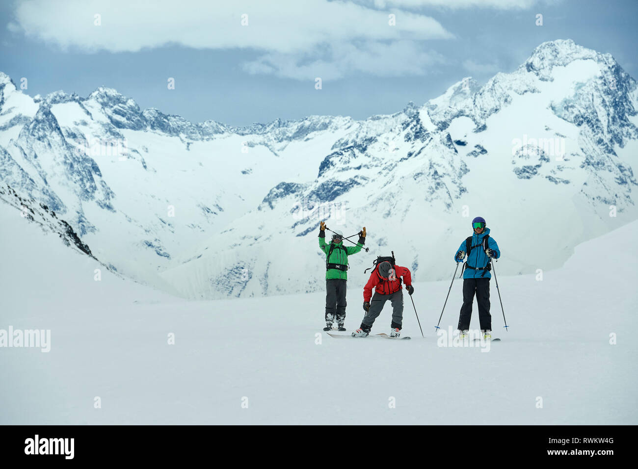 Landscape with three male skiers, portrait, Alpe-d'Huez, Rhone-Alpes, France Stock Photo