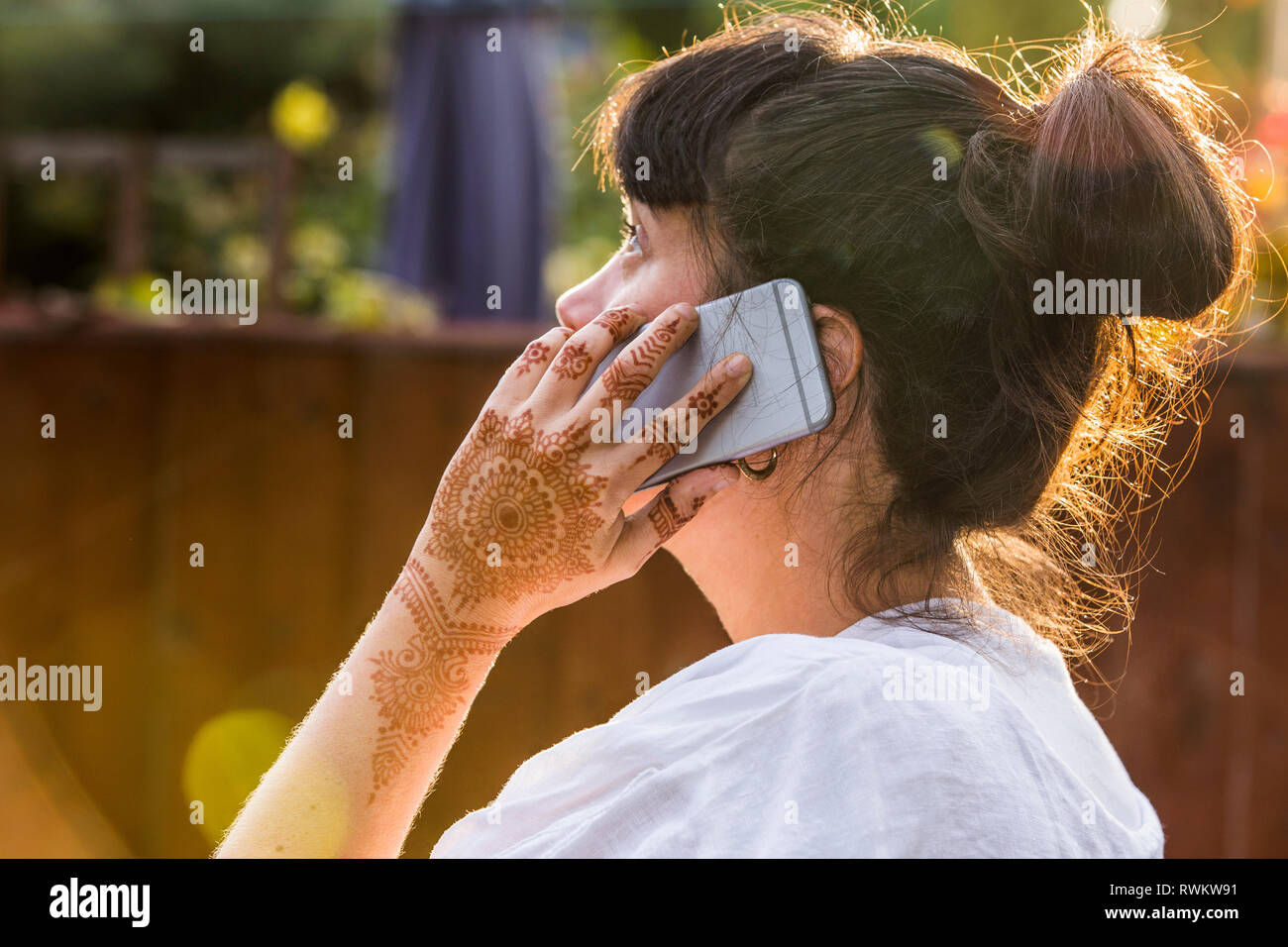 Woman with henna tattoo on hand using smartphone Stock Photo