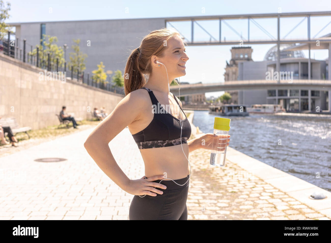 Young woman taking break from exercise in city, Berlin, Germany Stock Photo
