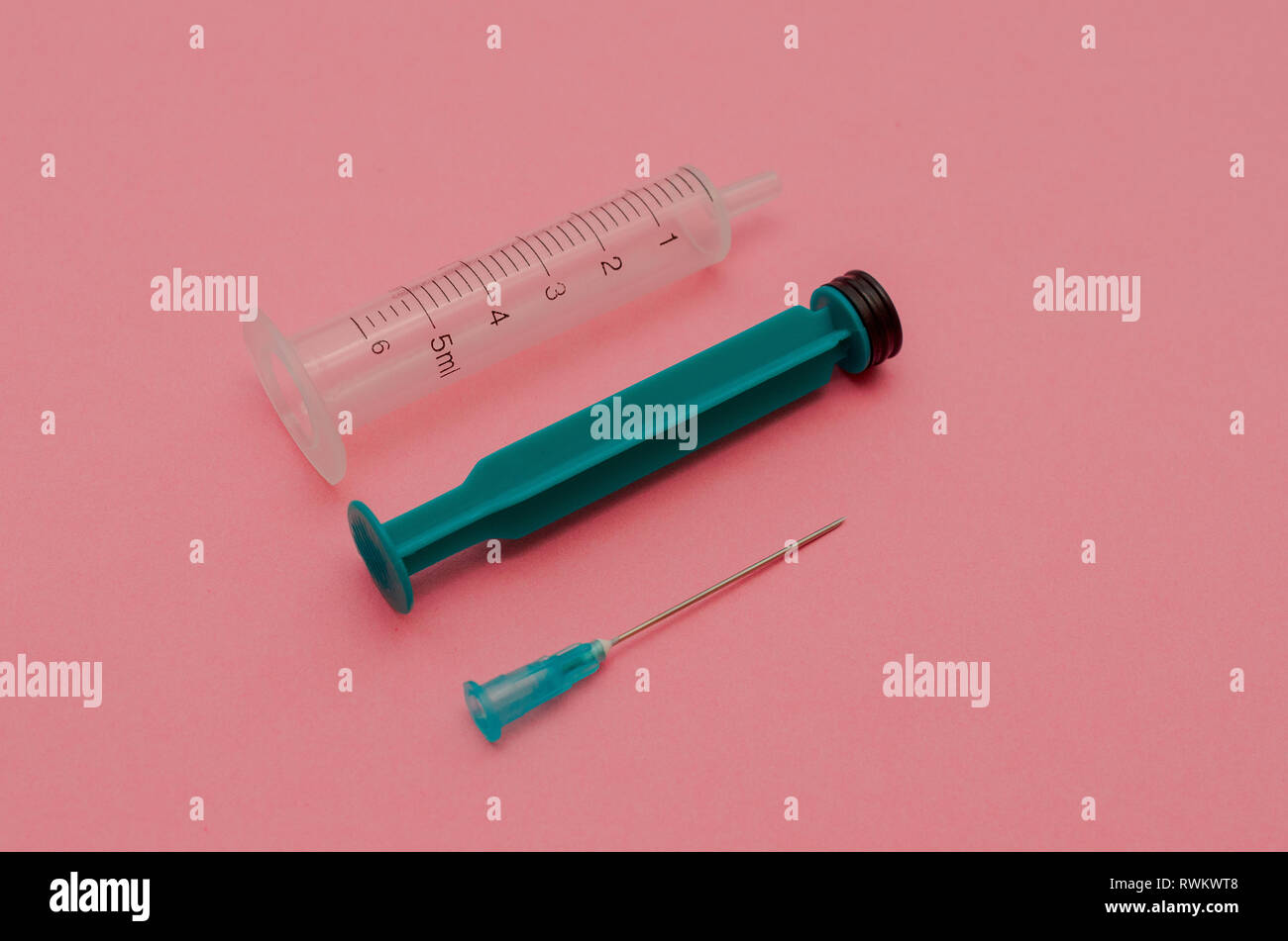 Syringe with green piston on a pink background. The concept of health Stock Photo