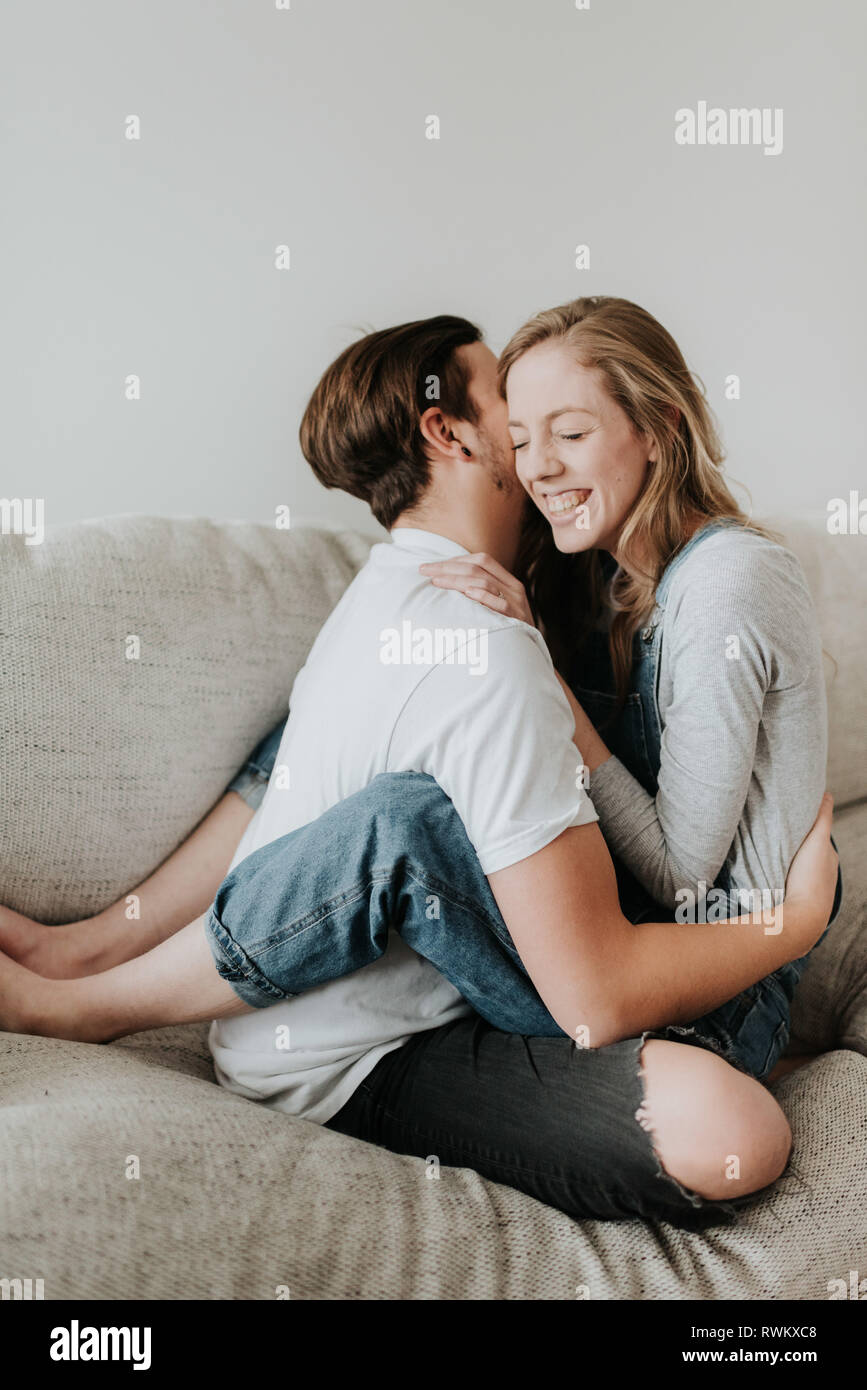 Couple hugging on sofa Stock Photo - Alamy