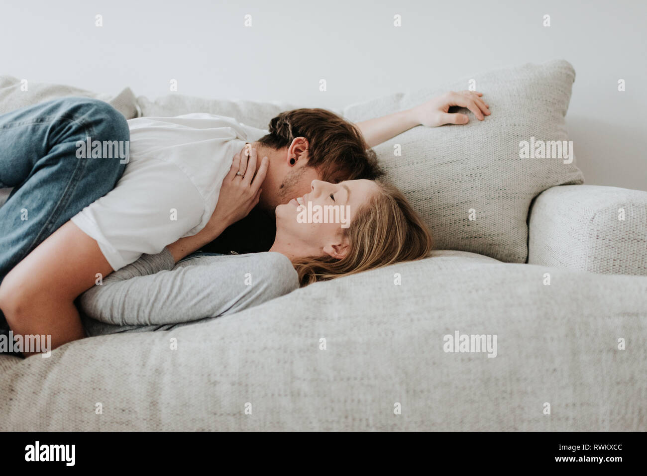 Couple hugging on sofa Stock Photo Alamy