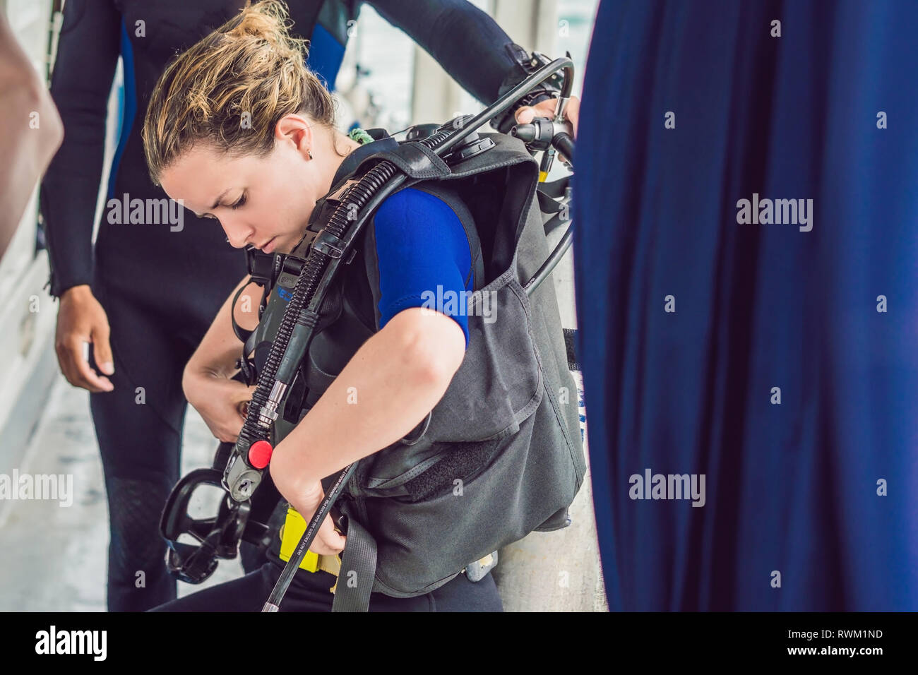 Diving instructor helps a beginner diver prepare for diving Stock Photo