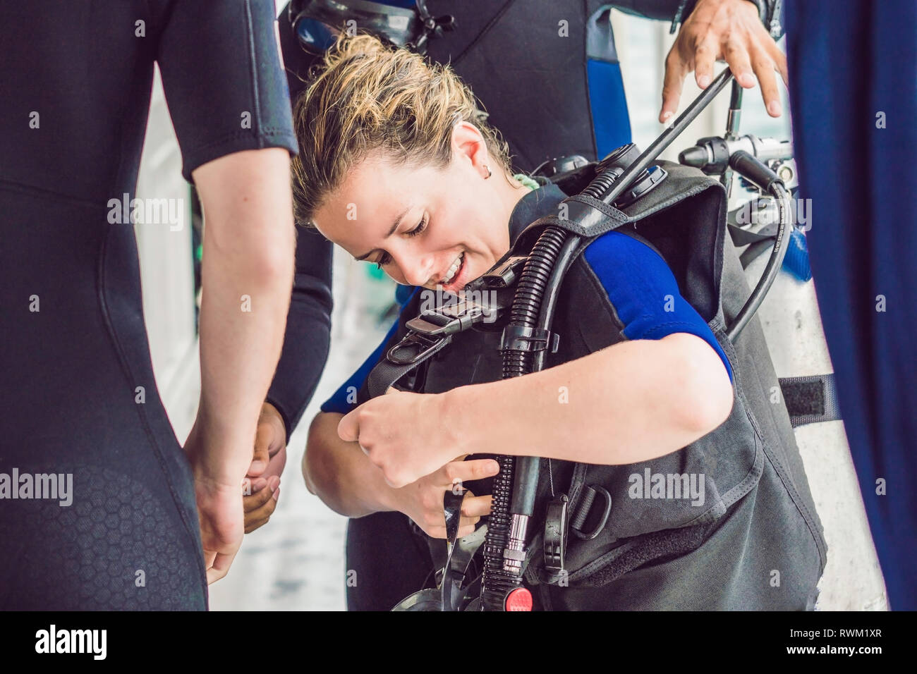 Diving instructor helps a beginner diver prepare for diving Stock Photo