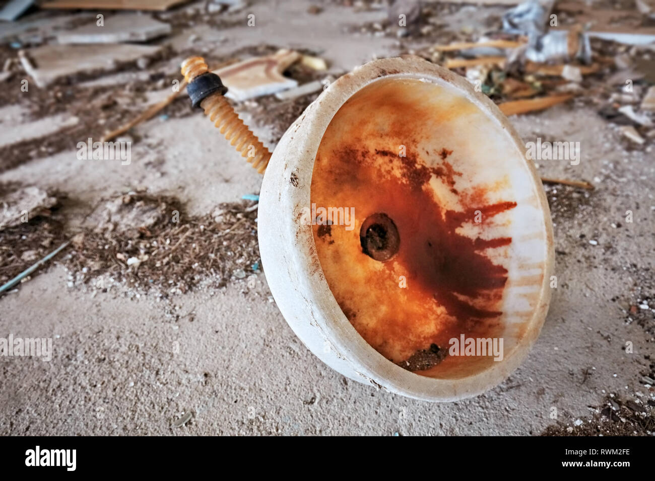 Rusty and dirty marble sink thrown away on the floor of an abandoned building Stock Photo