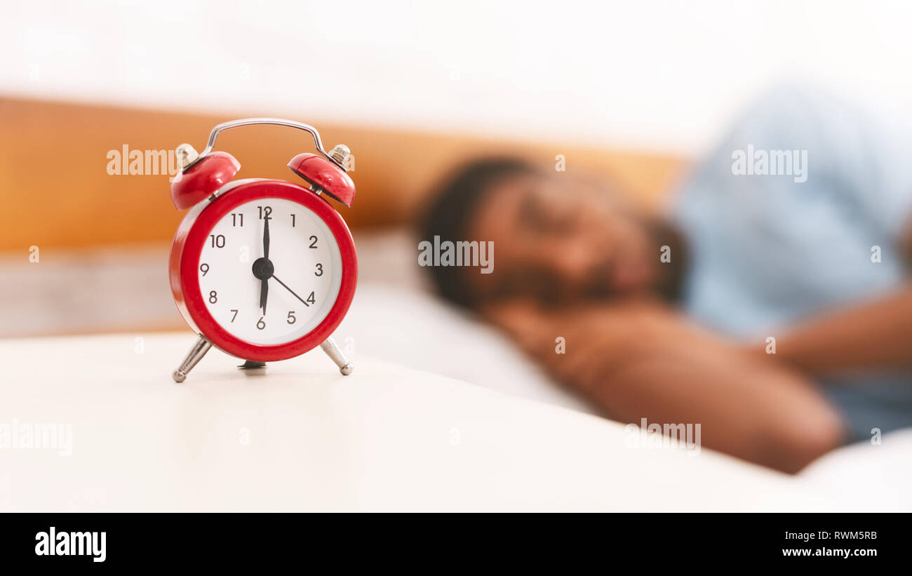 Man sleeping with alarm clock on foreground Stock Photo