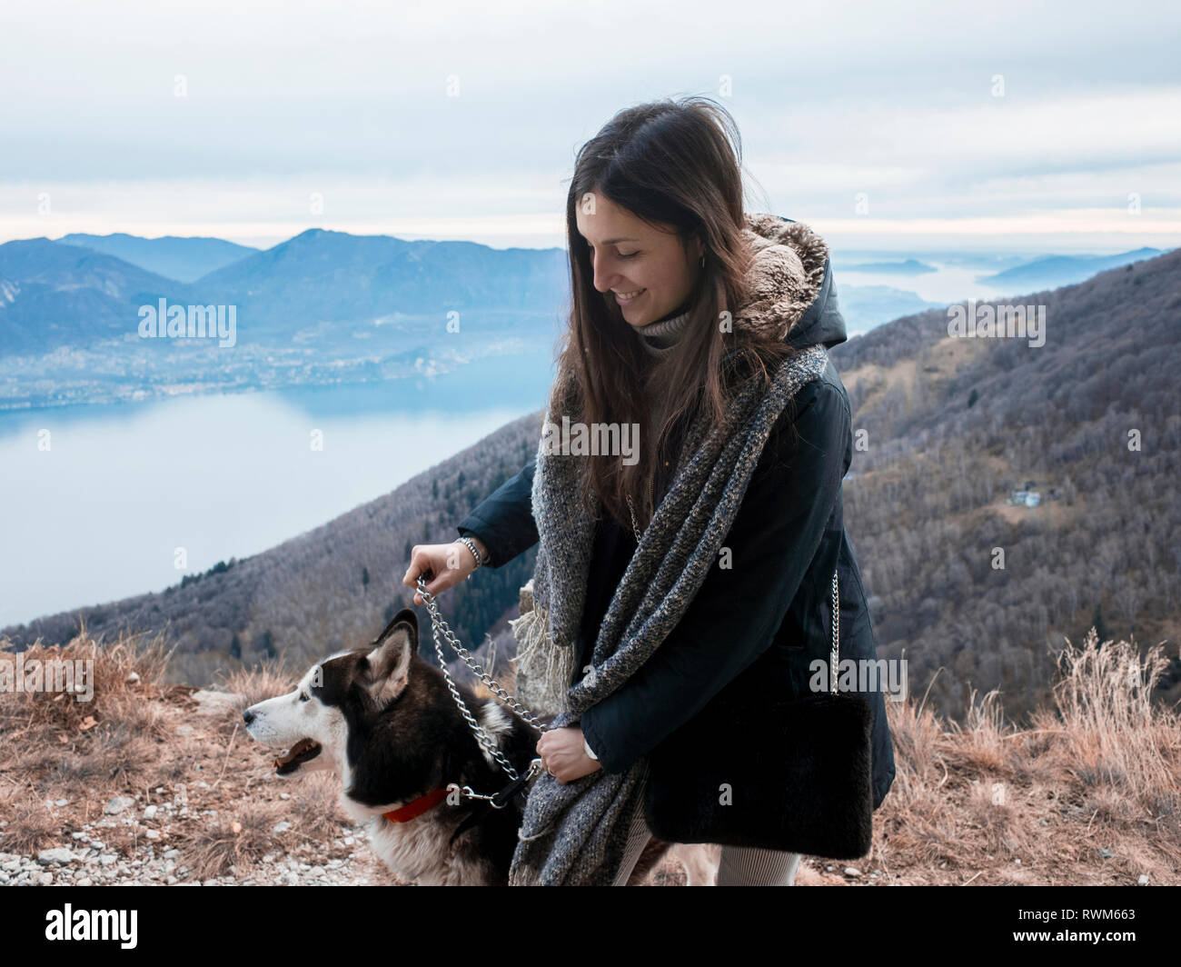 Woman walking dog on hilltop, Premeno, Piemonte, Italy Stock Photo