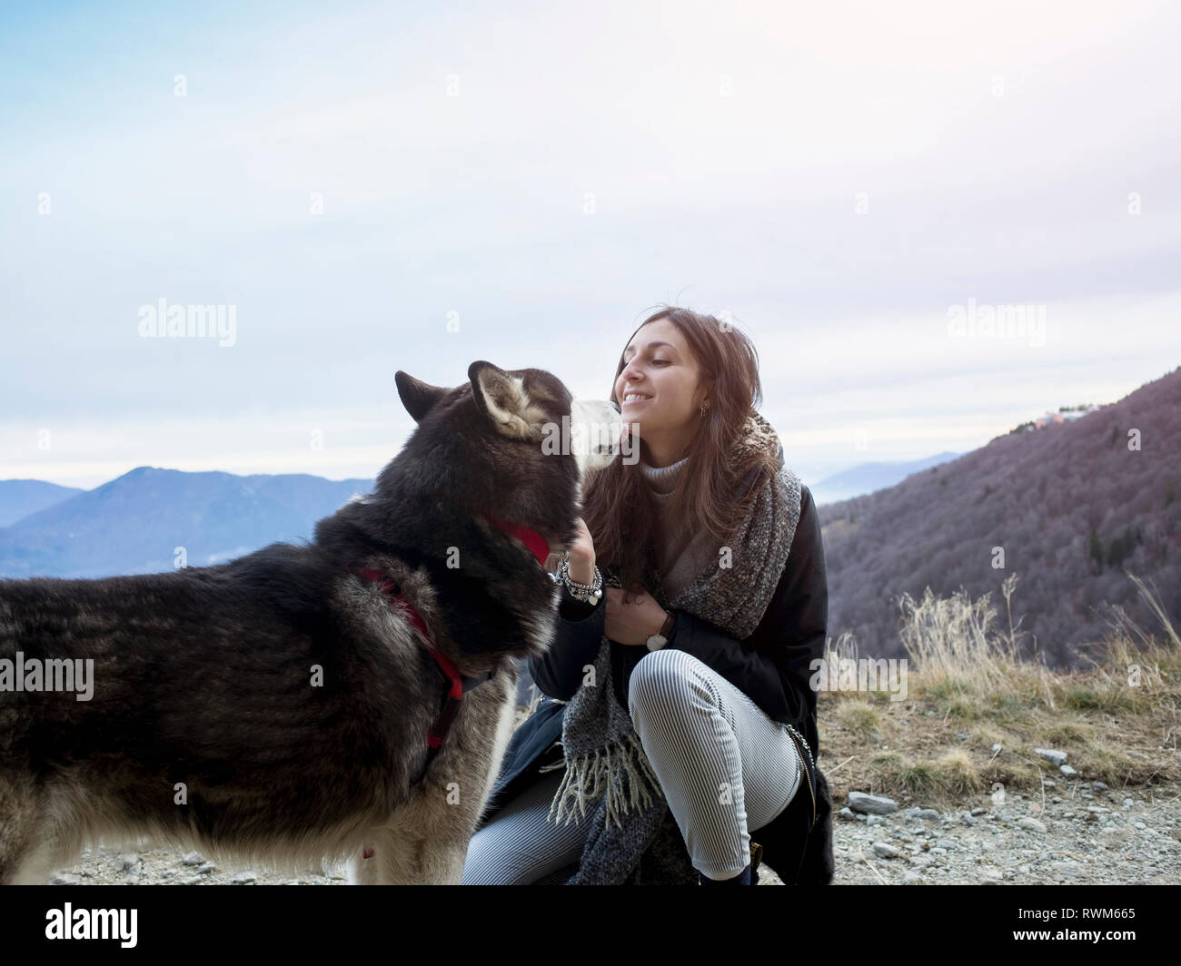 Woman walking dog on hilltop, Premeno, Piemonte, Italy Stock Photo