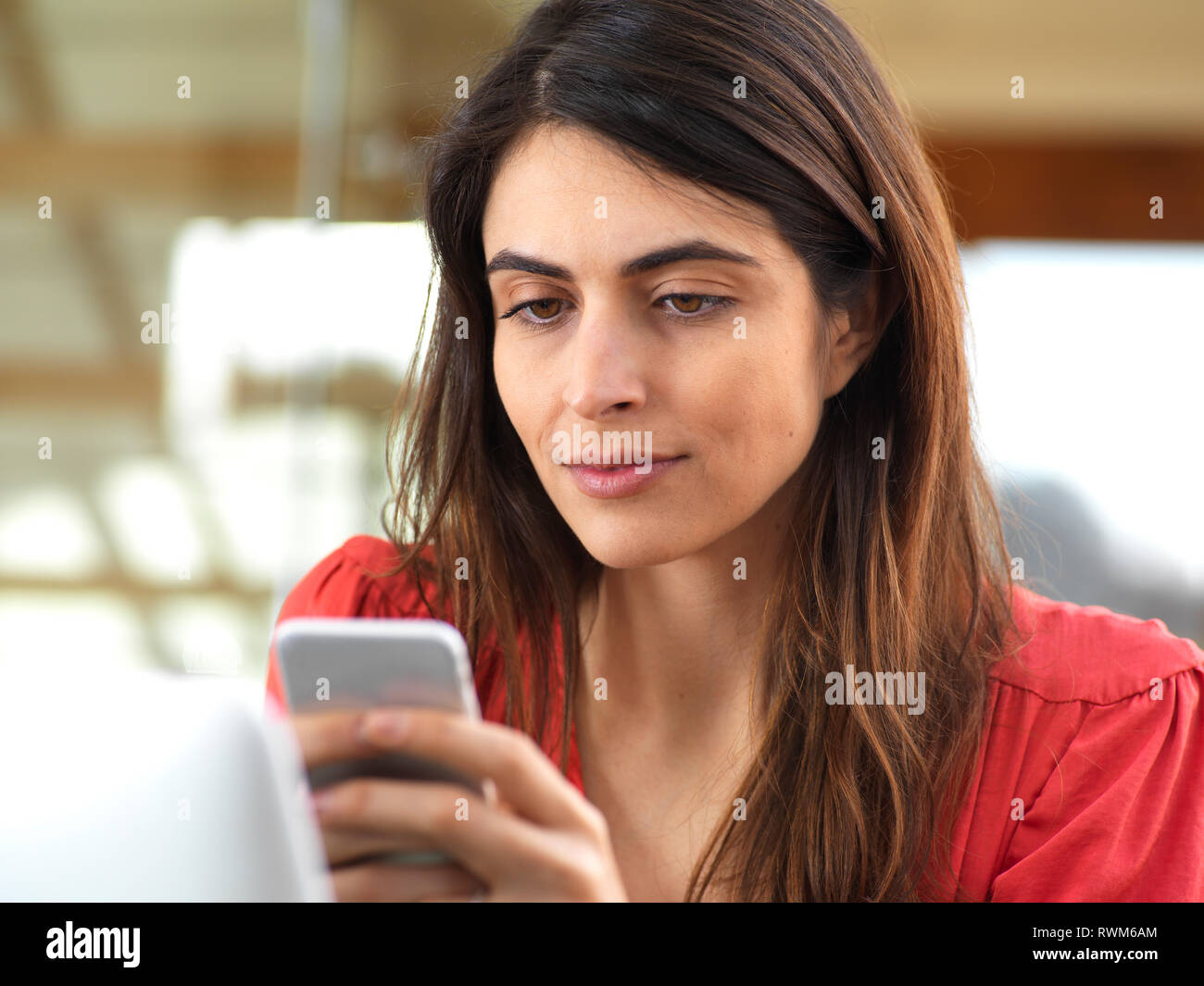 Woman working at computer and using mobile phone in office Stock Photo