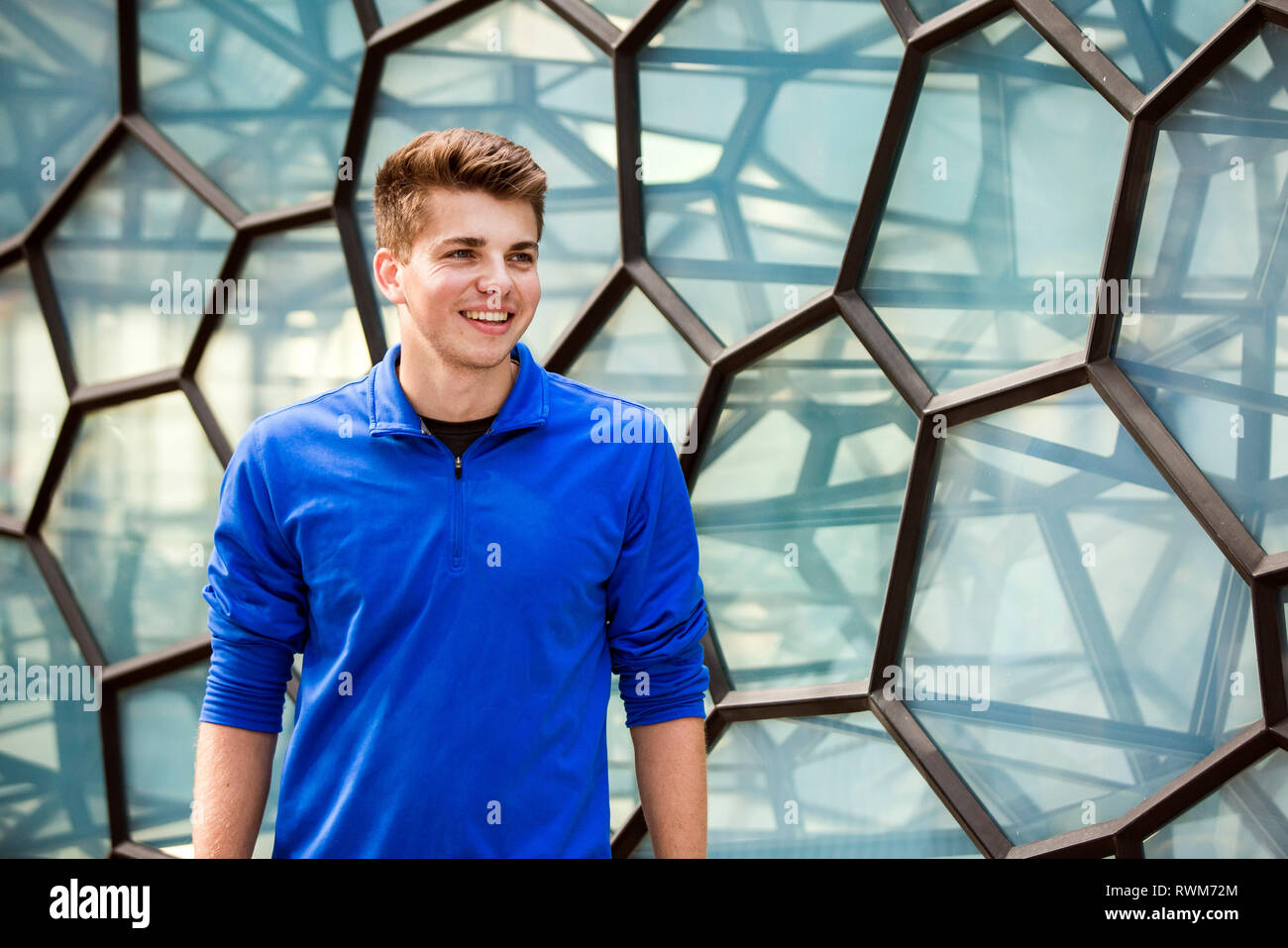 Young man standing front wall hi-res stock photography and images - Alamy