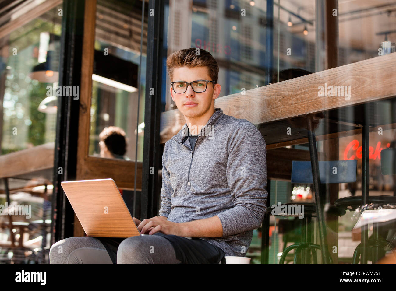 Young man using laptop at cafe, London, UK Stock Photo