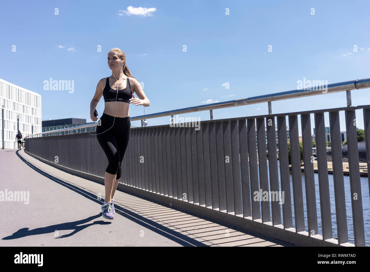 Young woman running in city, Berlin, Germany Stock Photo