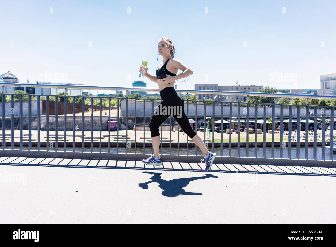 Young woman running in city, Berlin, Germany Stock Photo