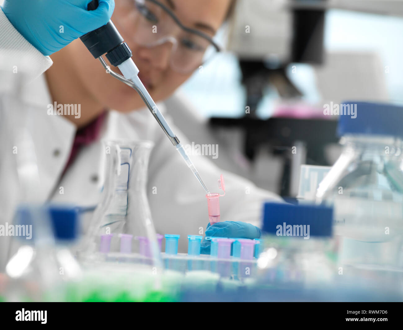 Scientist pipetting sample into vial during genetic experiment in laboratory Stock Photo