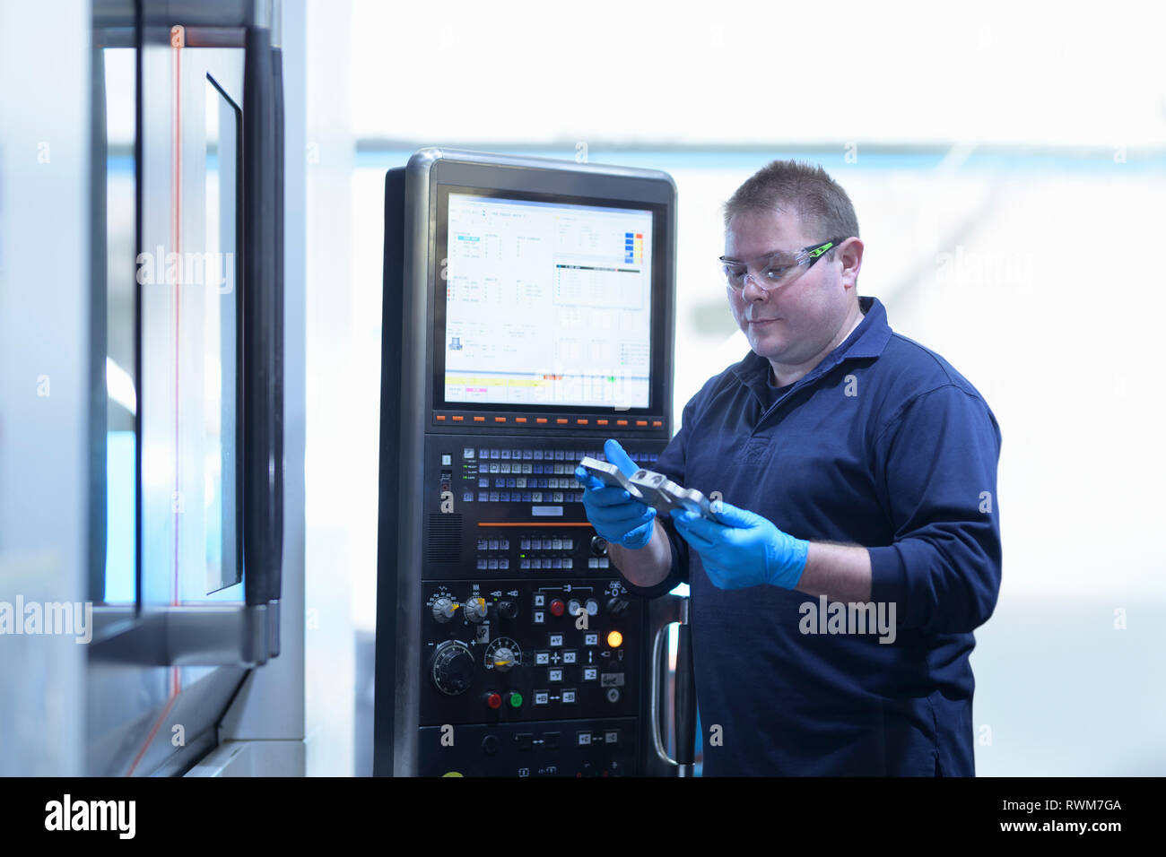 Engineer inspecting finished component in engineering factory Stock Photo
