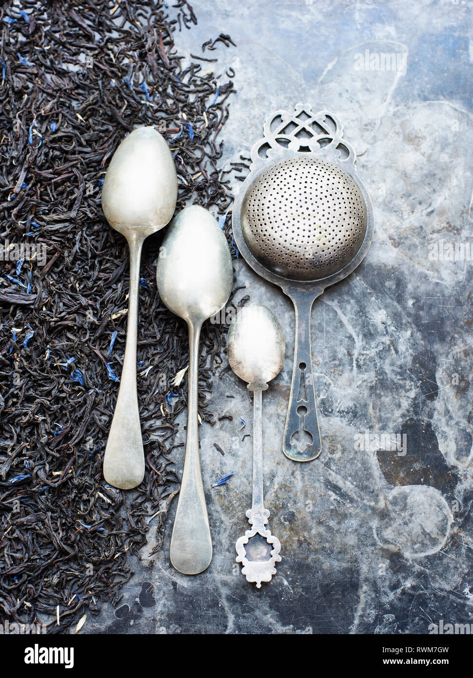 Tea leaves, tea strainer and silver spoons Stock Photo Alamy