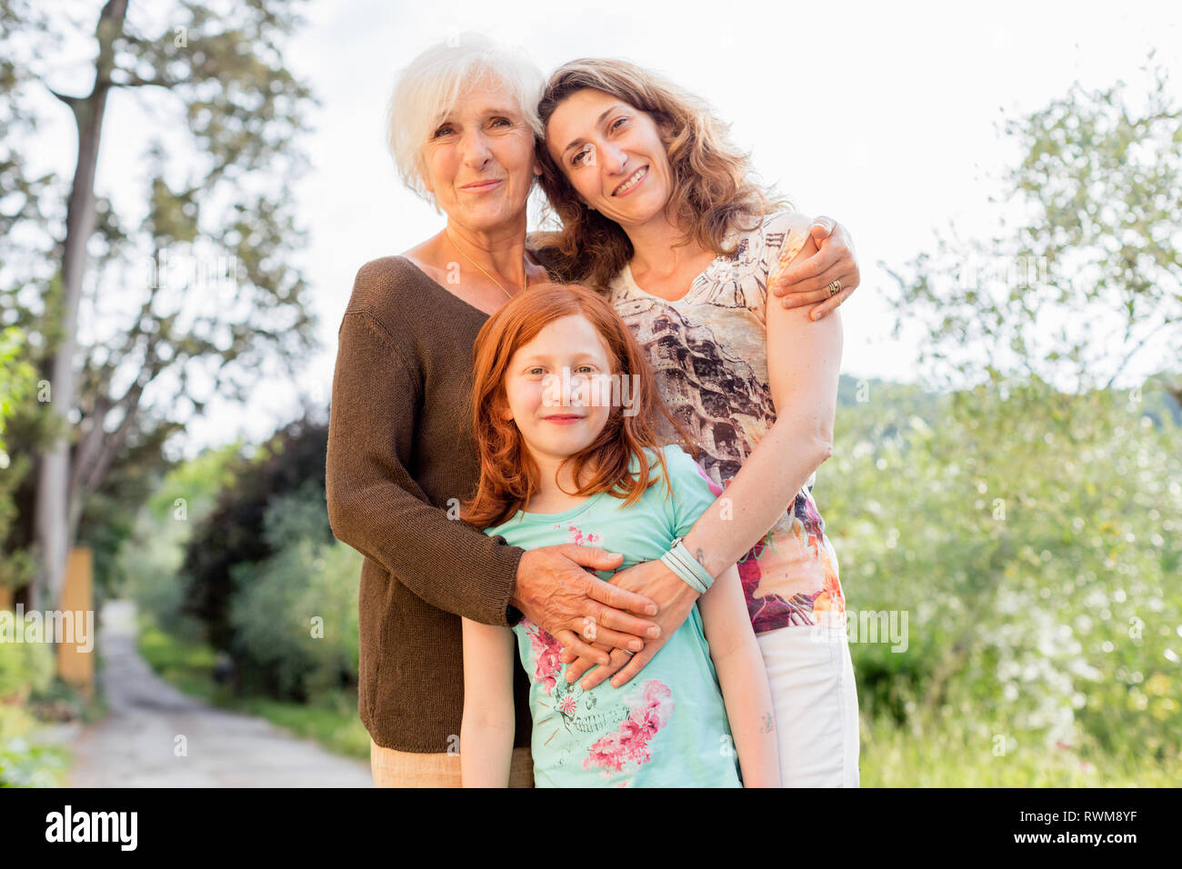 Girl on rural road with mother and grandmother, portrait Stock Photo