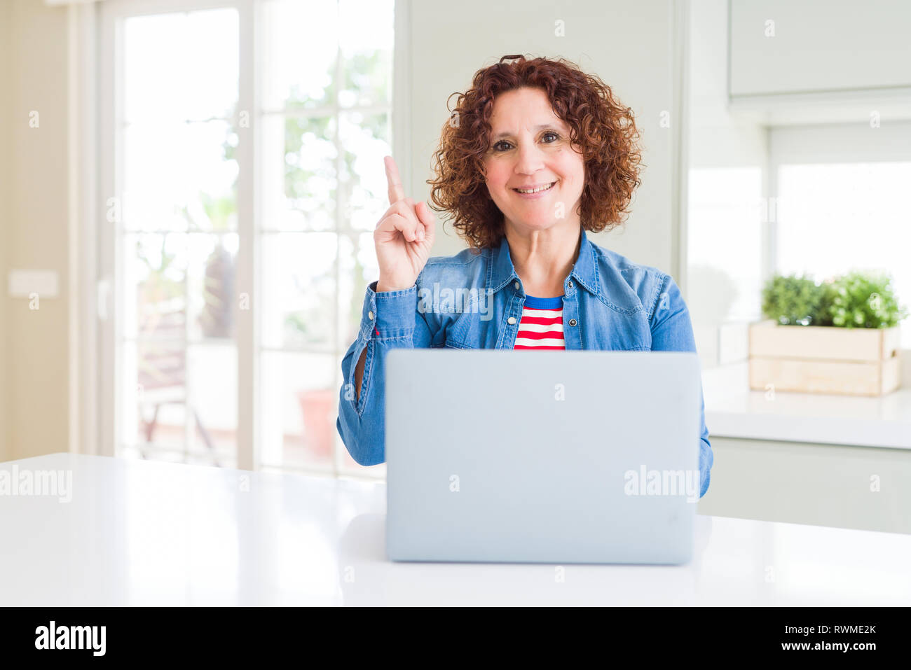 Senior woman working using computer laptop surprised with an idea or ...