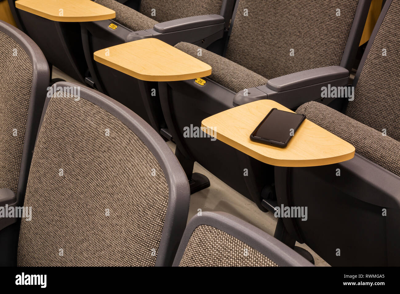 Cell phone on a student's desk in an empty college lecture hall; Connecticut, United States of America Stock Photo