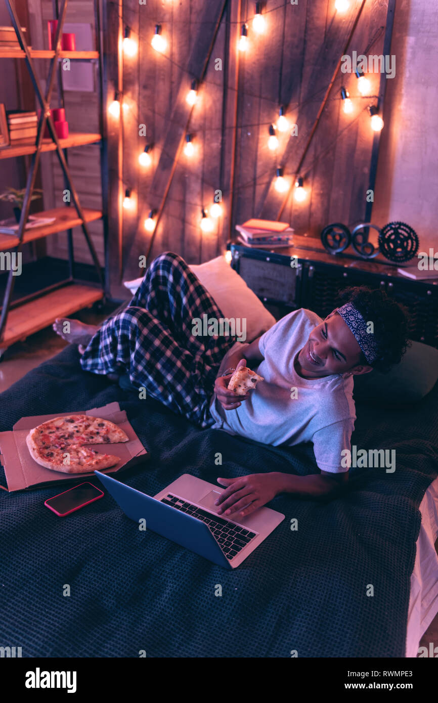 Smiling guy ordering pizza for dinner for not to be distracted from work. Stock Photo