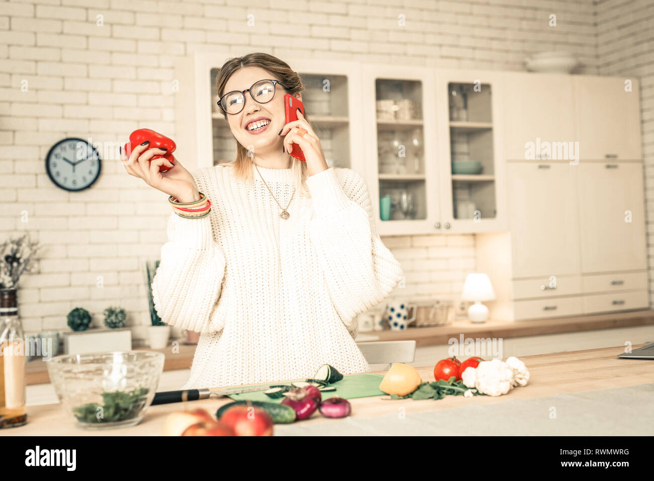 Cheerful chatty lady in white oversize sweater pleasantly talking Stock Photo