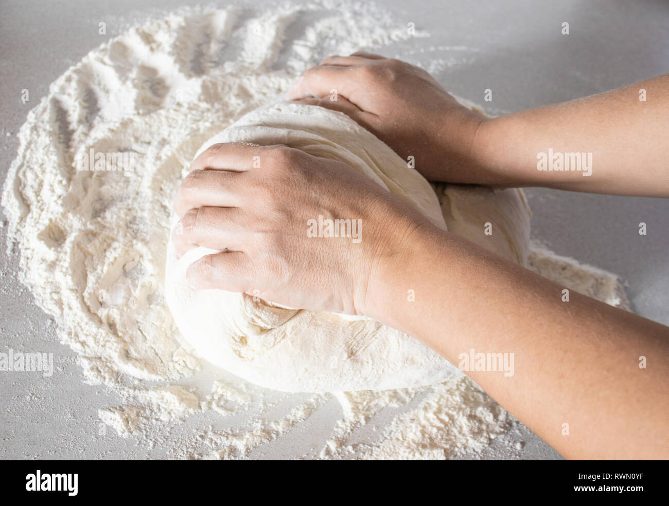 Girl kneads dough on a white table close-up. Stock Photo