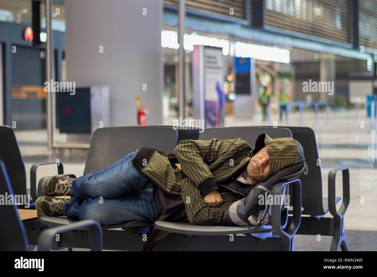 Passenger young man sleeping while waiting the plane at airport
