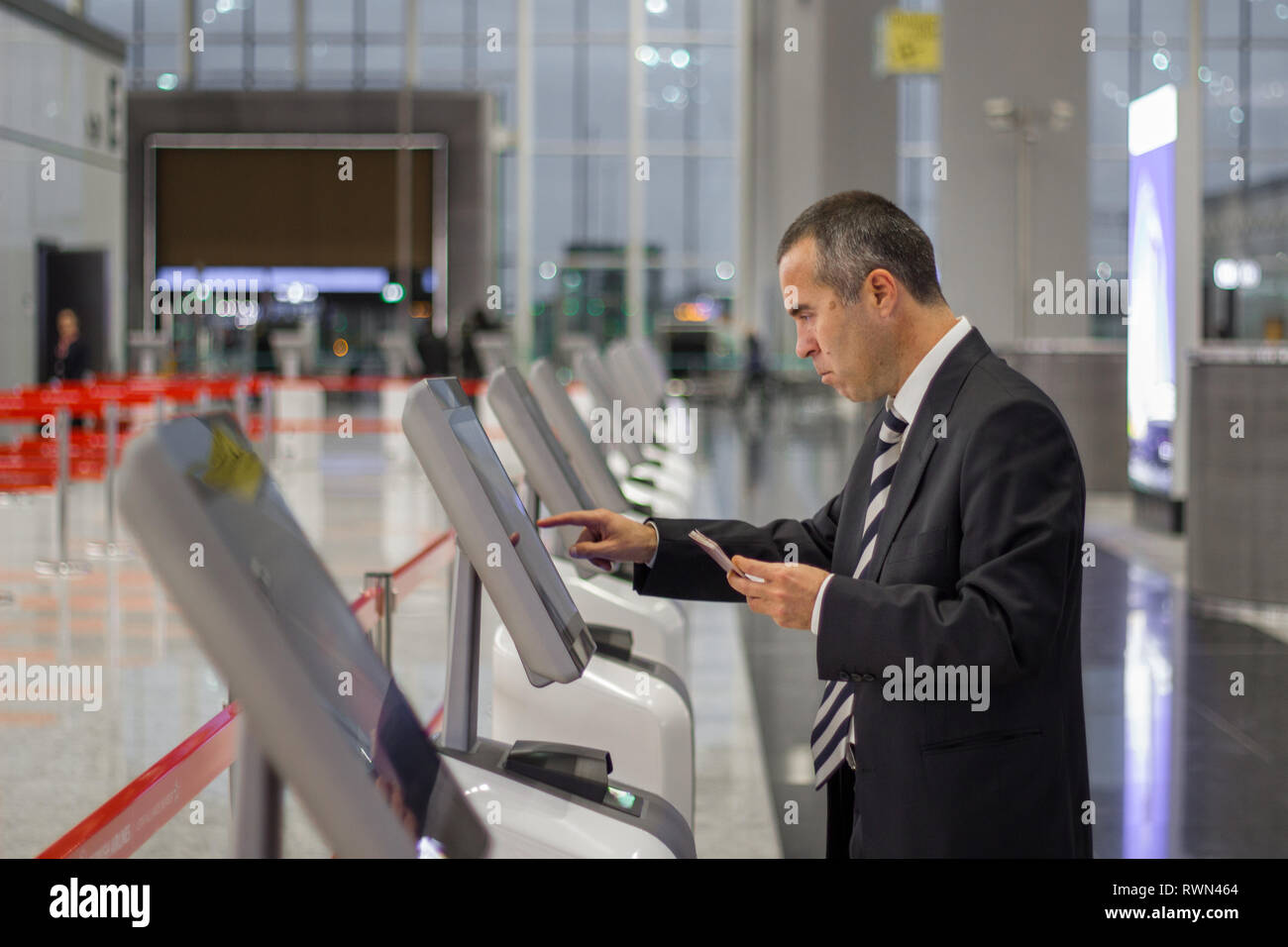 Passenger business man at the airport check in ticket at kiosk terminal Stock Photo