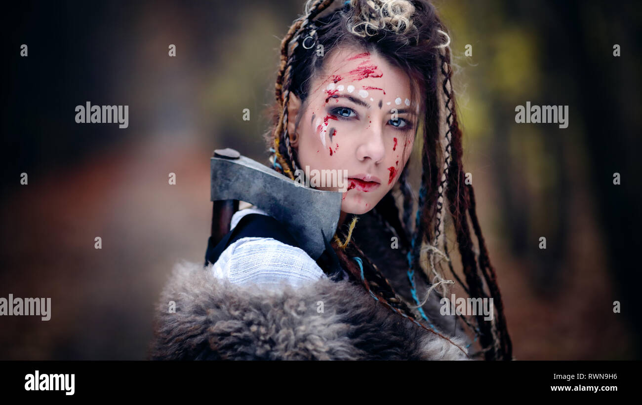 Warrior Beauty with trace of blood on her face. Viking Woman. Close-up portrait. Cinematic look Stock Photo