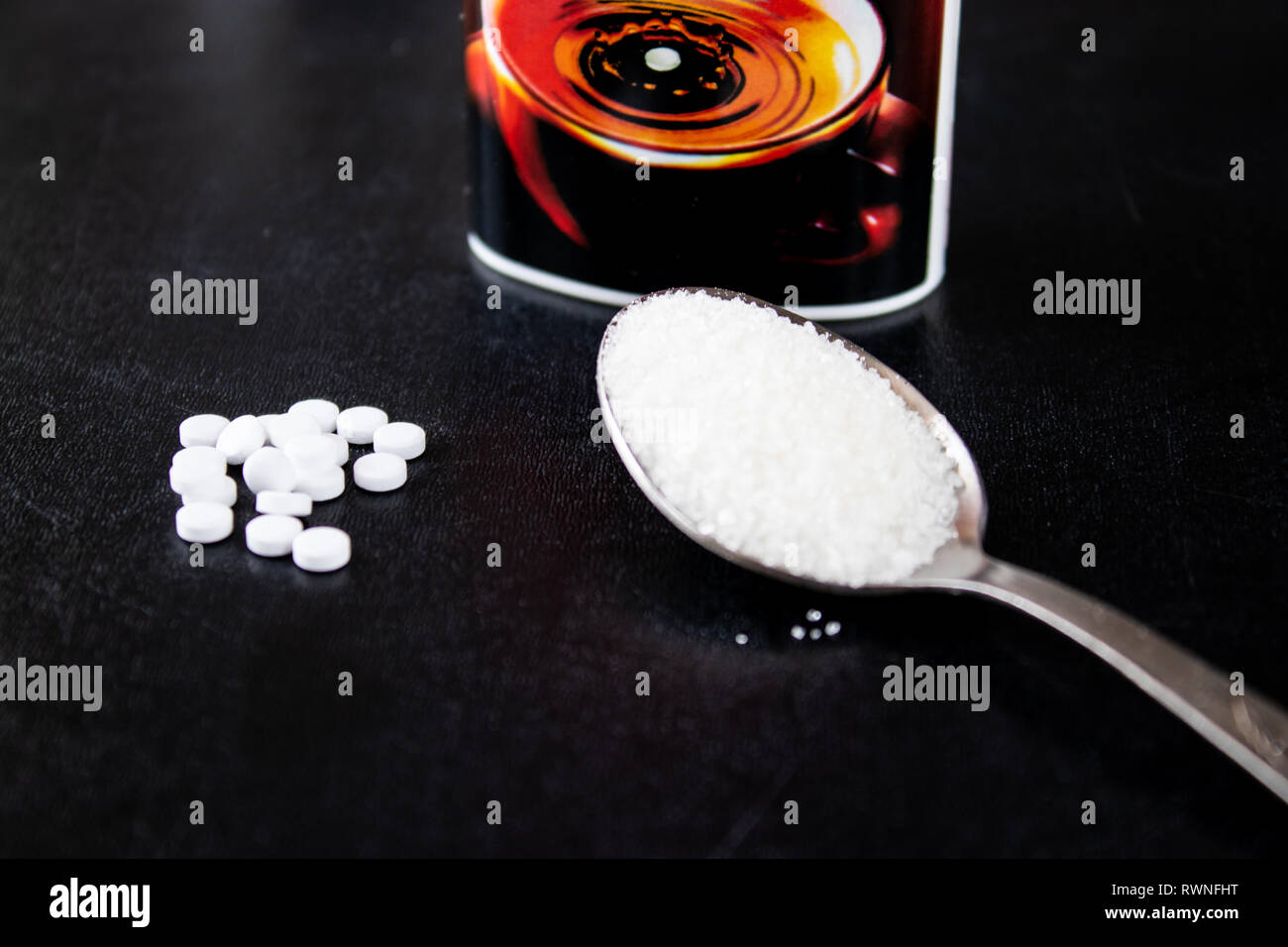 Fructose and sugar in a spoon on a black background. Sugar substitute, sweetener. Stock Photo