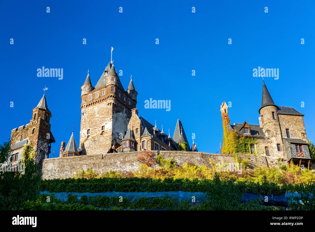 Looking up to old medieval stone castle with blue sky; Cochem, Germany Stock Photo