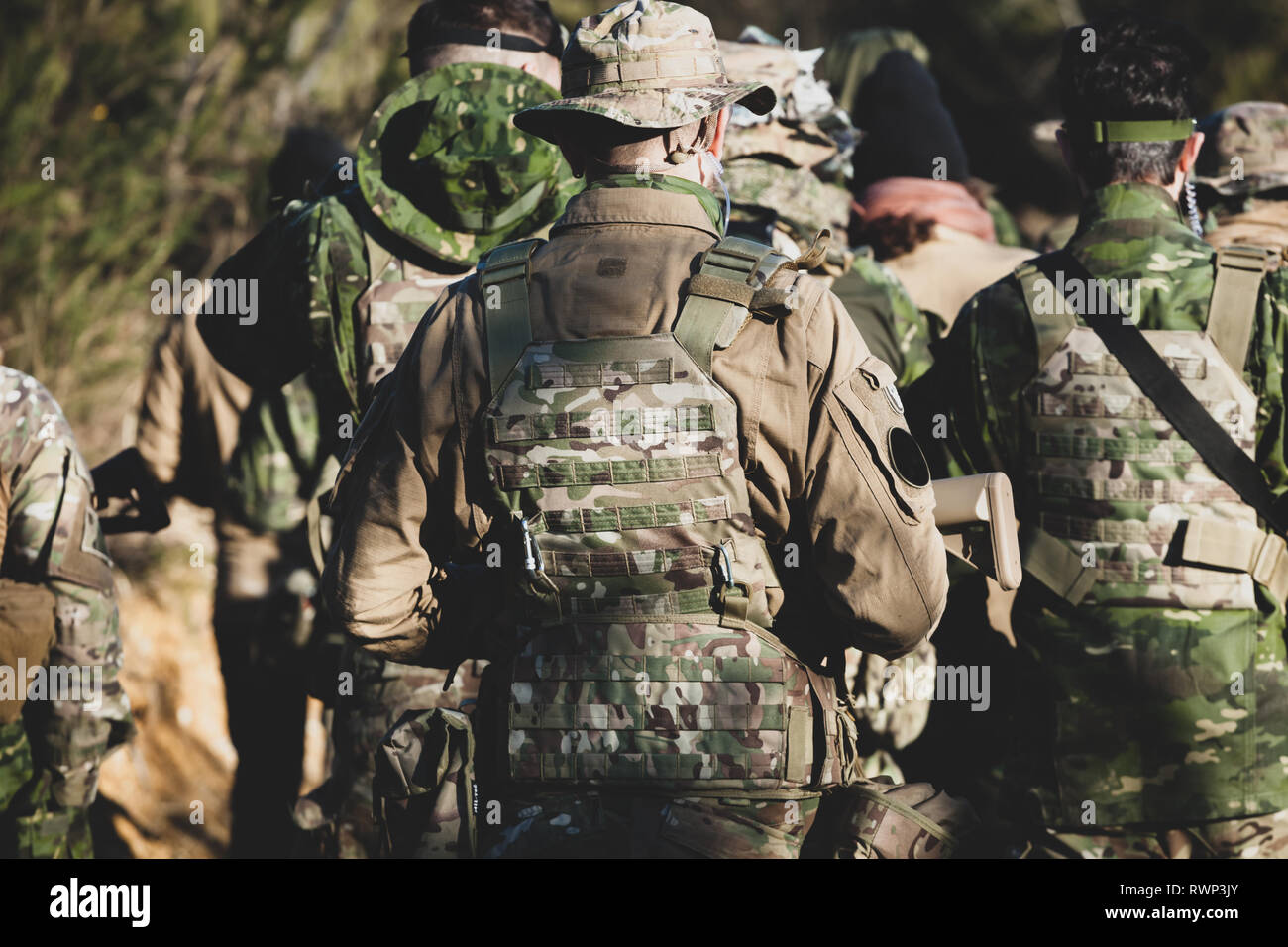 Airsoft military game players in camouflage uniform with armed assault rifle. Stock Photo