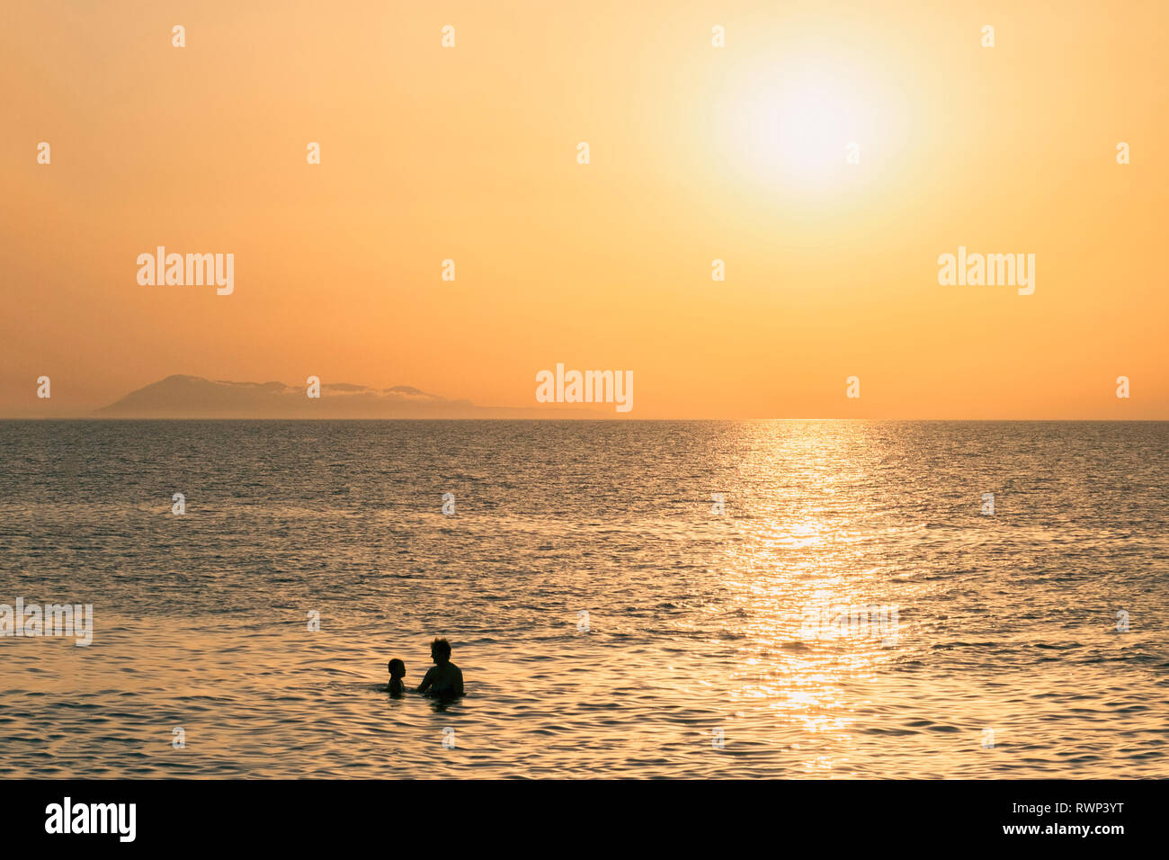 Mother and son on the sea during sunset Stock Photo