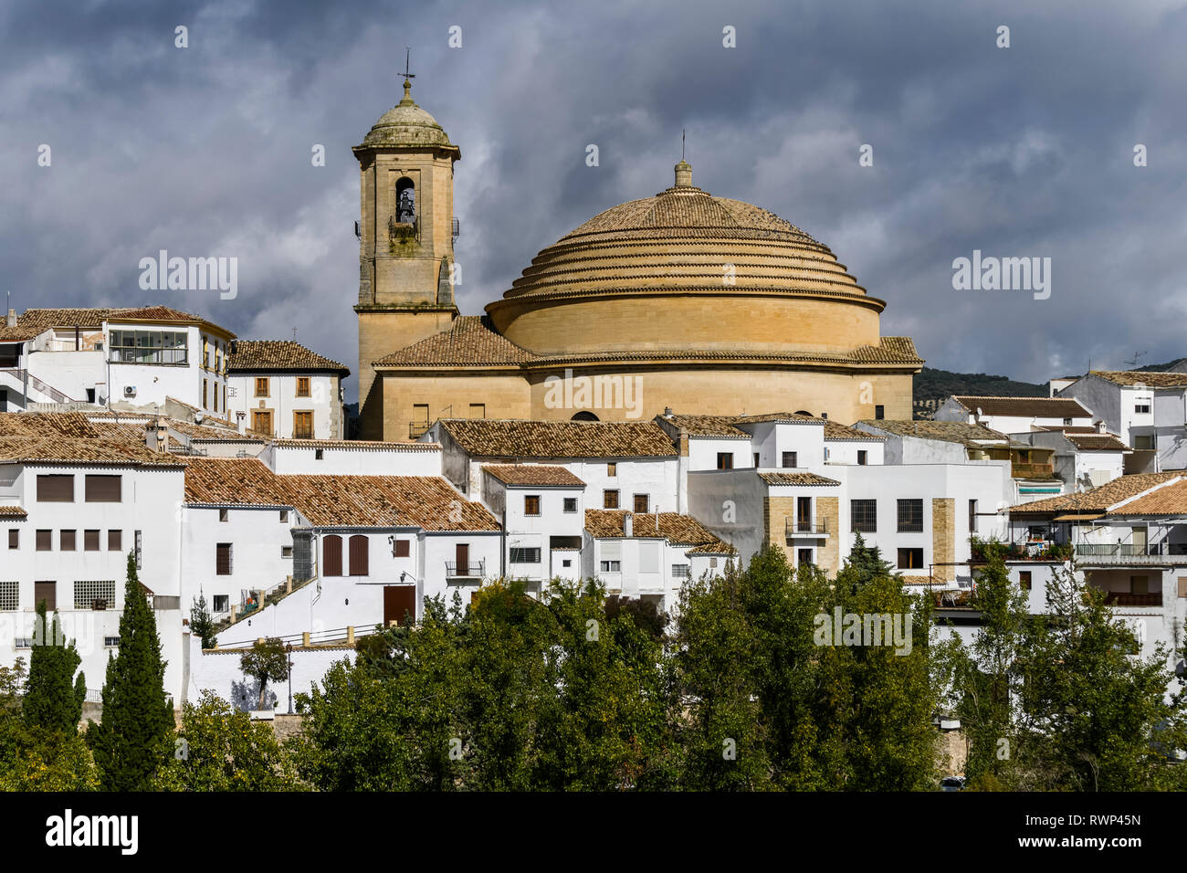 Bell tower and domed roof of Iglesia de la Encarnacion church with white houses below; Montefrio, Province of Granada, Spain Stock Photo