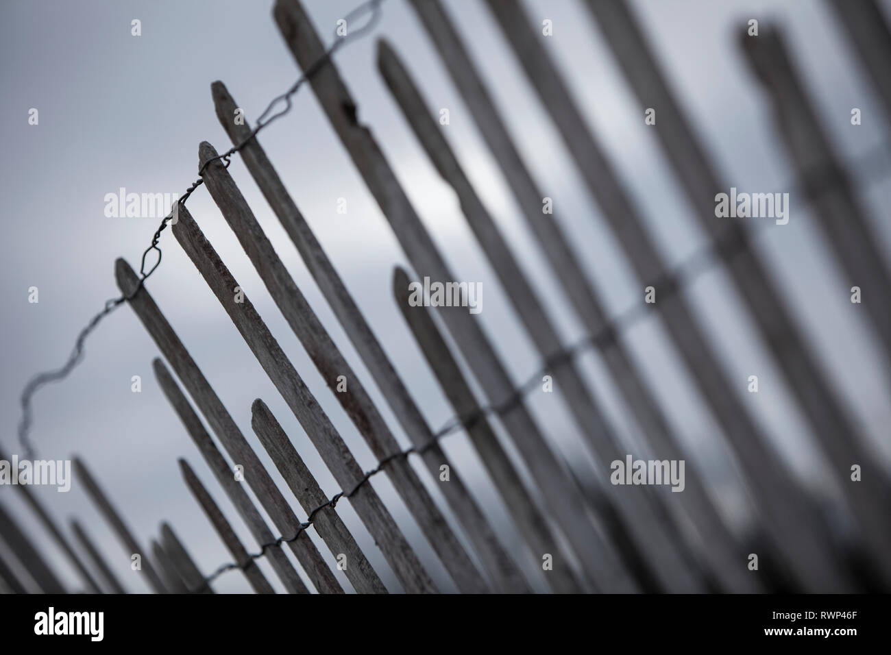 Simple fence with wire and narrow wooden boards that are broken in un-even lengths; Ontario, Canada Stock Photo