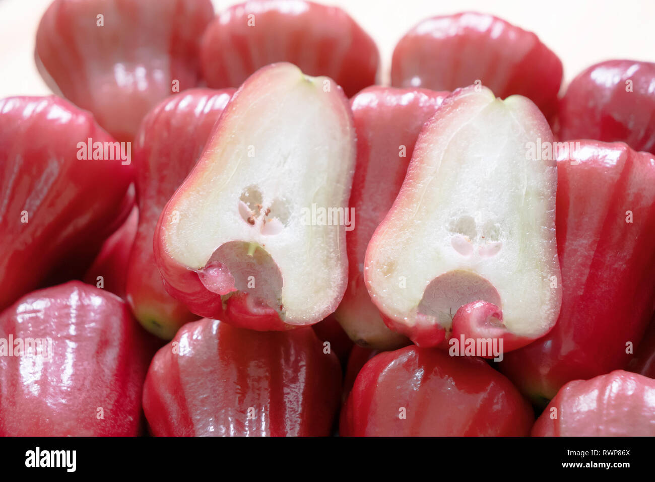 Syzygium is a genus of flowering plants. That can be eaten. Close up half rose apple on the pile. Stock Photo