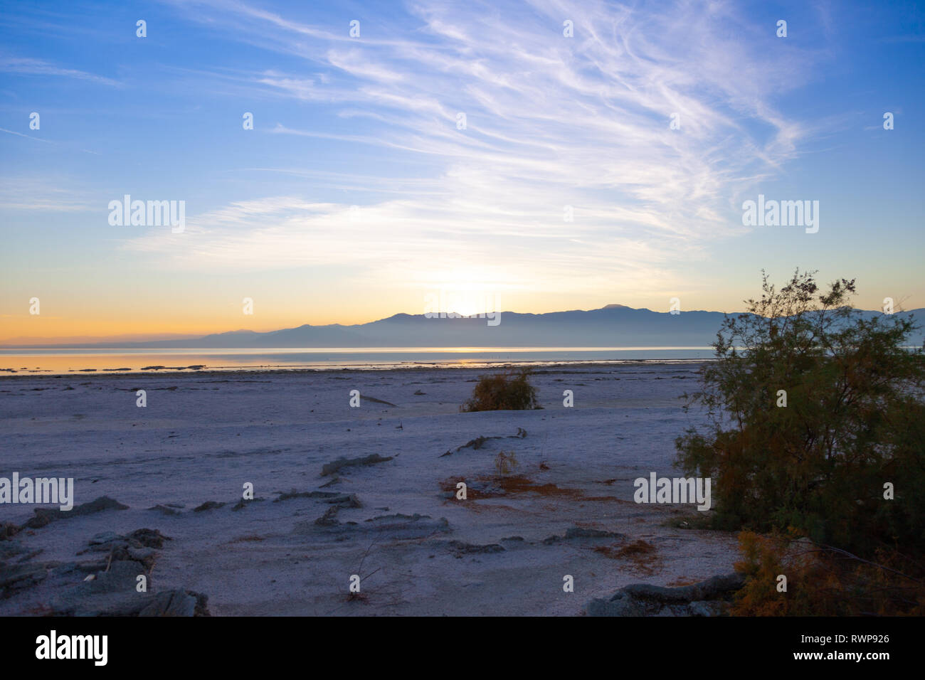 Beautiful sunset with wispy clouds and mountains at the Salton Sea in North Shore, California Stock Photo