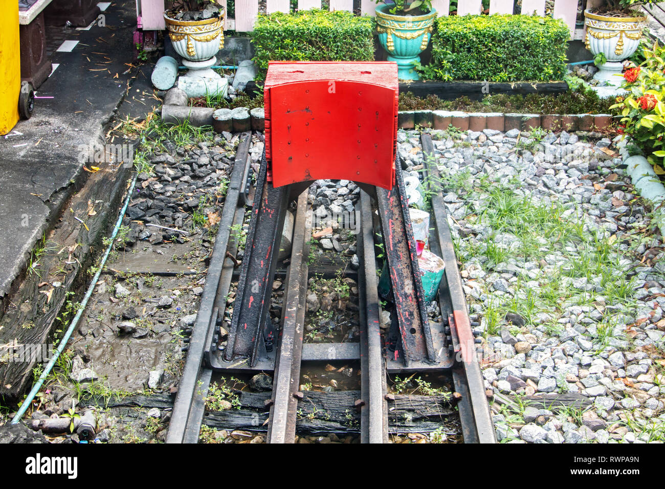 Old red buffer stop at the end of railway tracks on railway station. Stock Photo