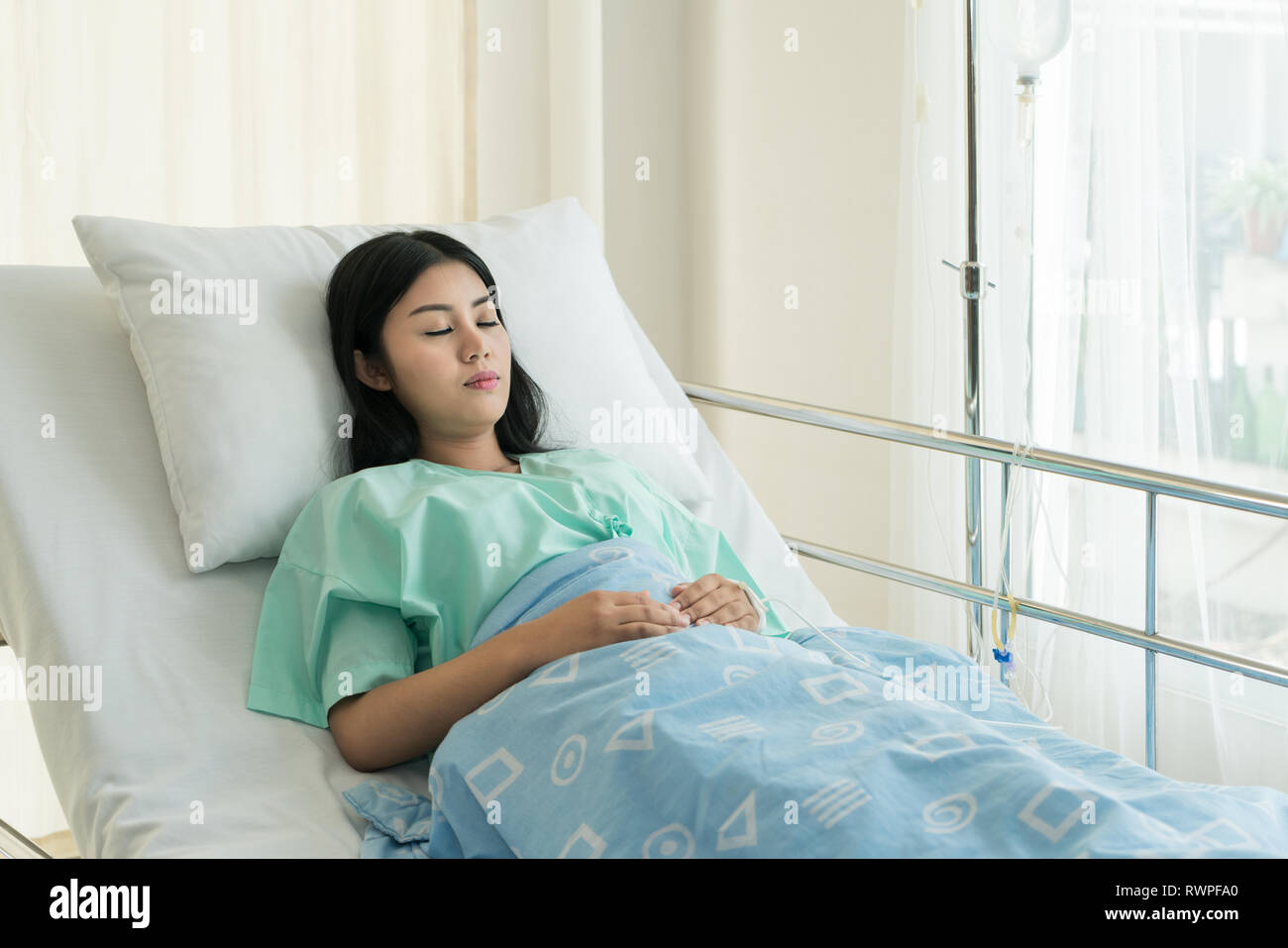 Asian patient woman sleeping and lying on her bed while receiving in hospital. Stock Photo