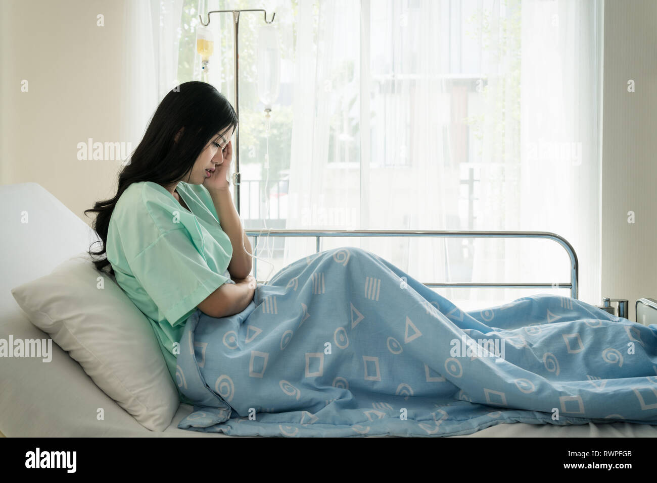 Asian young woman patients lying in the room. Asian patients had severe headaches in hospital. Stock Photo