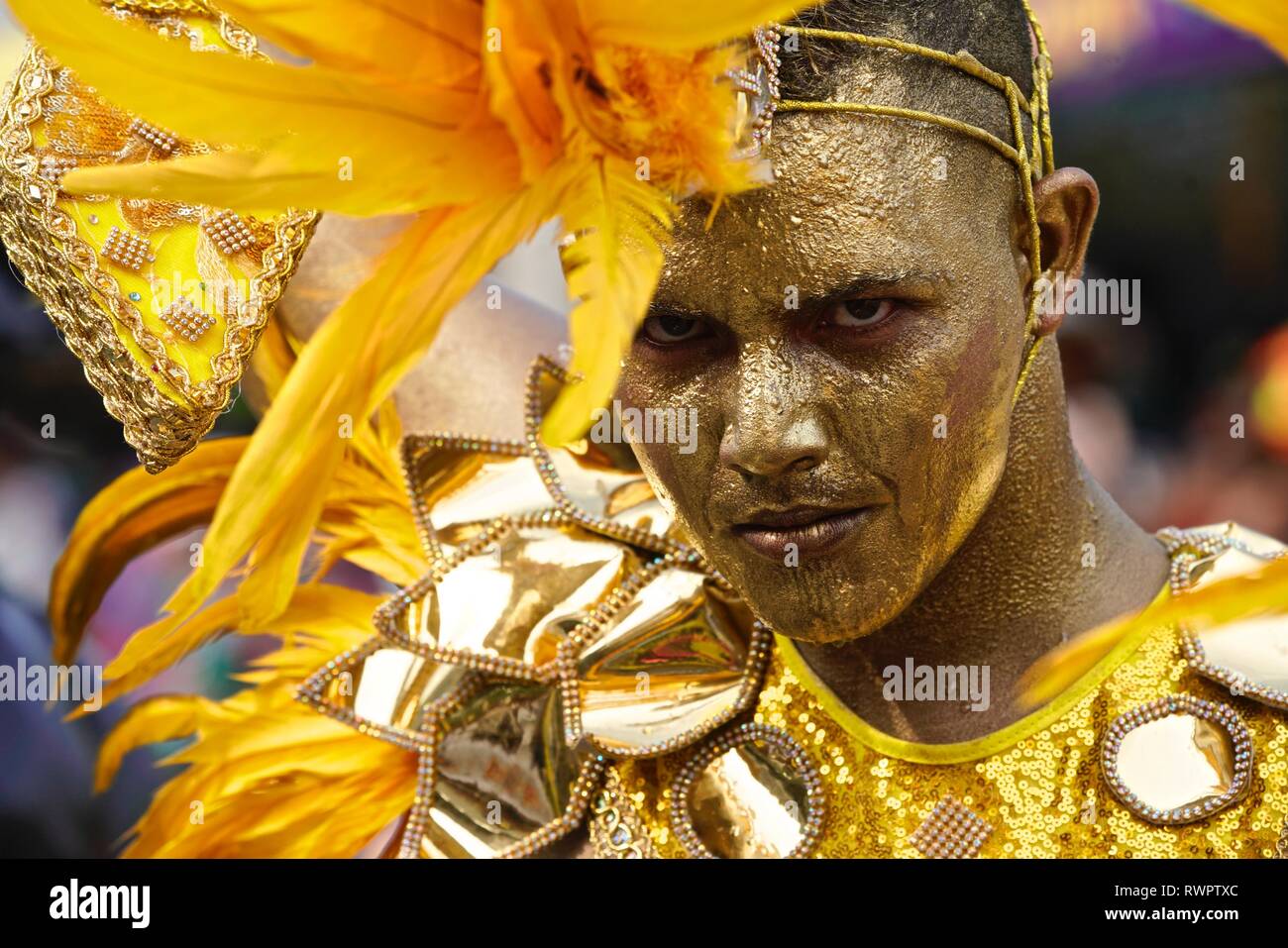 Dancers wearing golden costumes at the Battle of Flowers Stock Photo