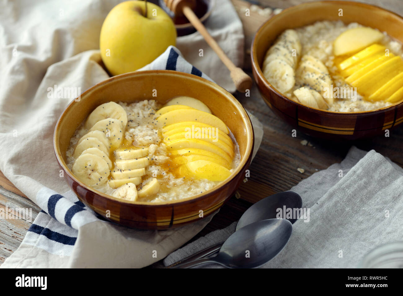 Healthy breakfast. Oatmeal with fruits (apples, bananas) and honey on