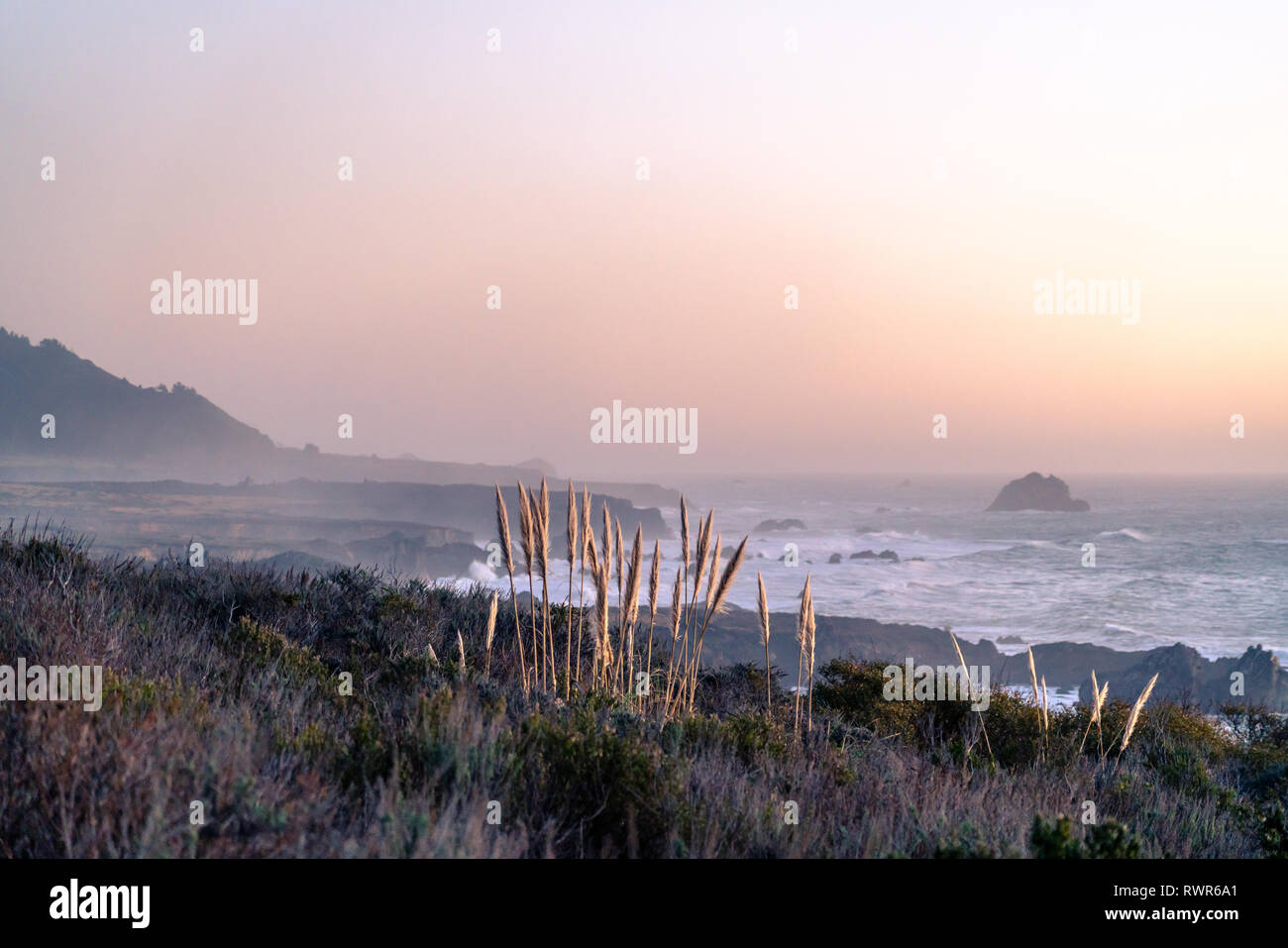 Big Sur, California - Pink sunset along the pacific coastline and Highway One on the west coast of the United States. Stock Photo